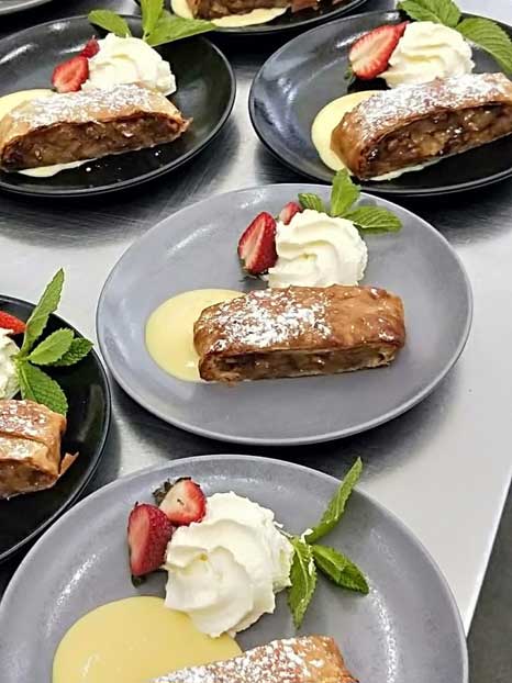Buffet dessert options including apple strudel and cream